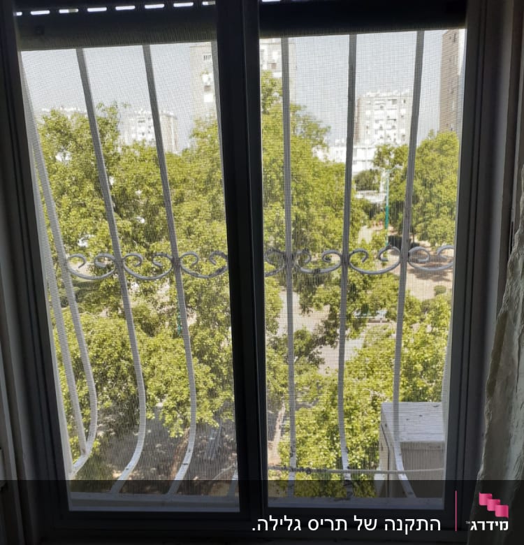 חלון אלומיניום עם סורגי מתכת נראים מבחוץ